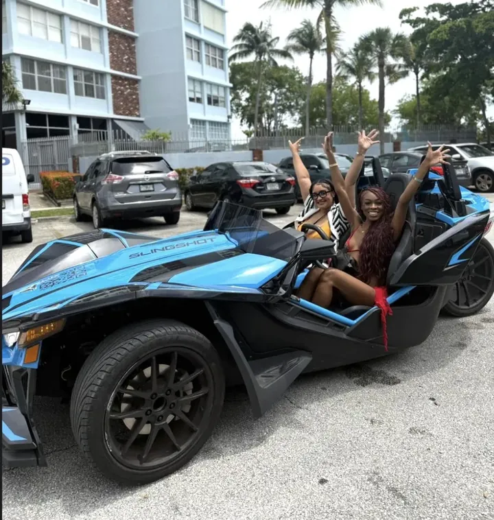 Blue Polaris Slingshot Miami Beach — two friends celebrating