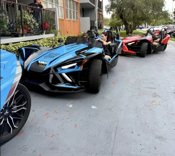 Green Polaris Slingshot rental Miami — smiling customers